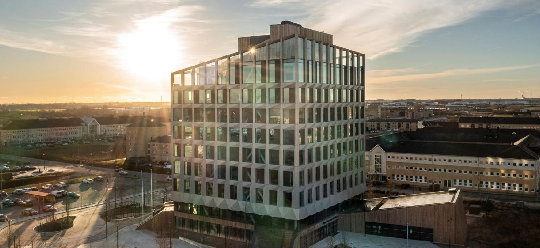 Modern office building in Høje-Taastrup bathed in golden hour sunlight