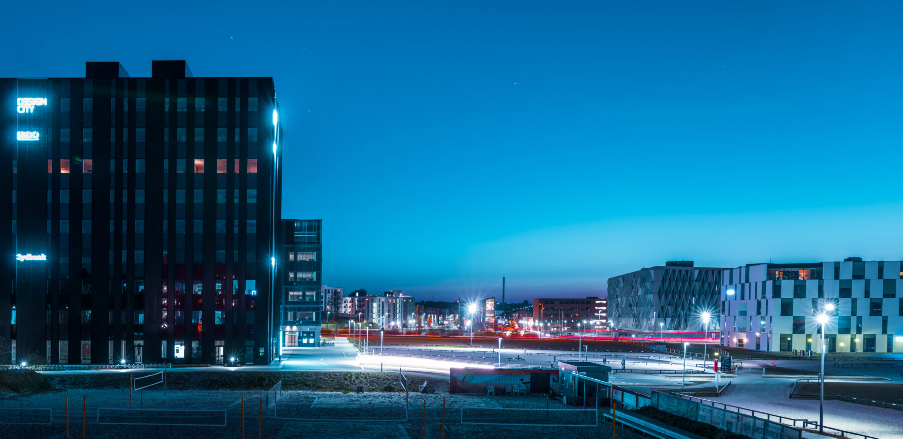 Night view of Kolding’s financial district featuring Design City and modern office buildings with illuminated facades.