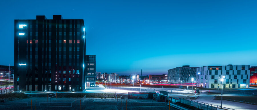 Night view of Kolding’s financial district featuring Design City and modern office buildings with illuminated facades.