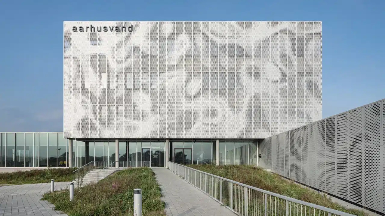 Front view of Aarhus Vand’s modern headquarters with perforated façade and landscaped entrance path