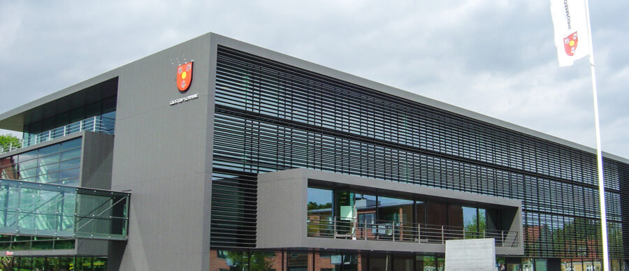 Modern facade of Glostrup Municipality’s town hall east wing with large horizontal louvres and glass bridge
