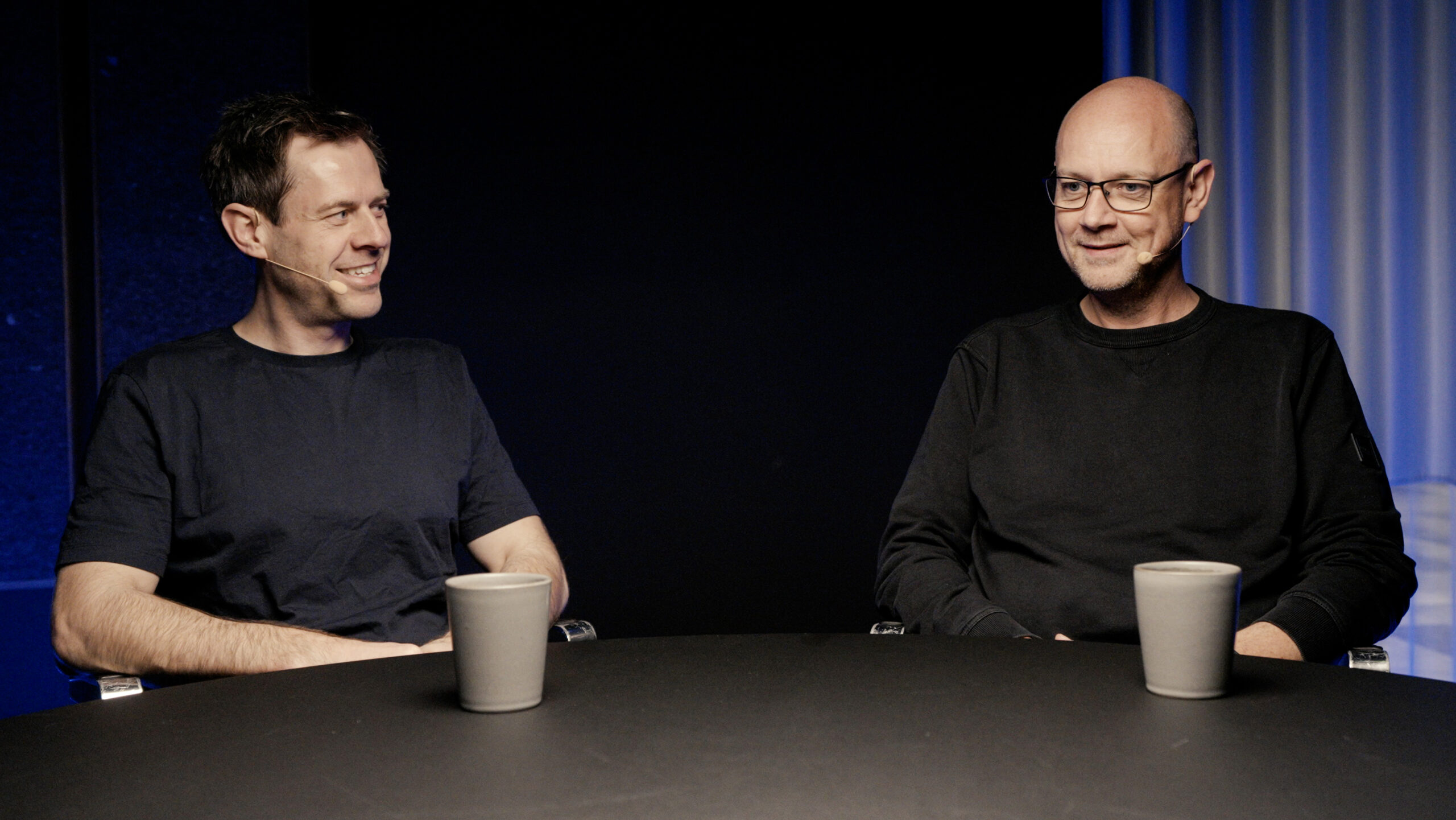 Christian Lillelund, CTO at Intellis, in conversation with another professional, sitting at a round table with microphones.