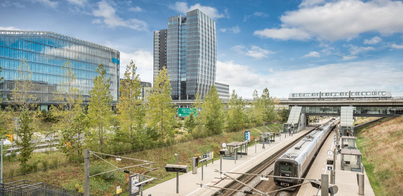 Modern office buildings at Copenhagen Towers with a train station and metro in the foreground