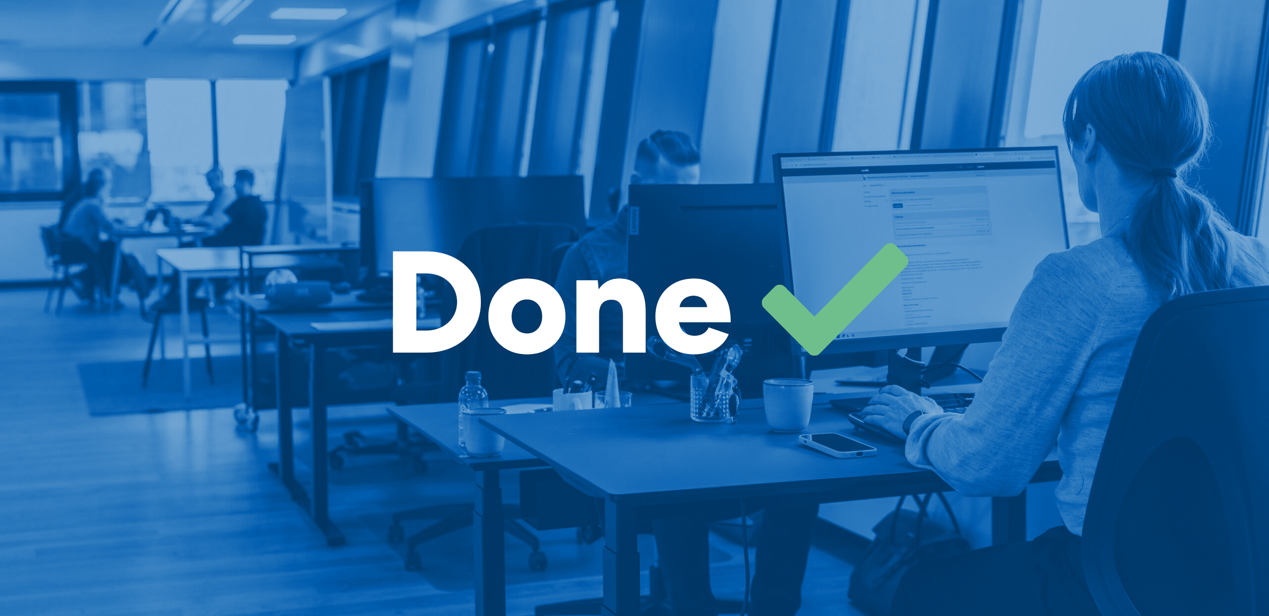 Office workspace with employees at computers, overlay text reading “Done” with a green checkmark