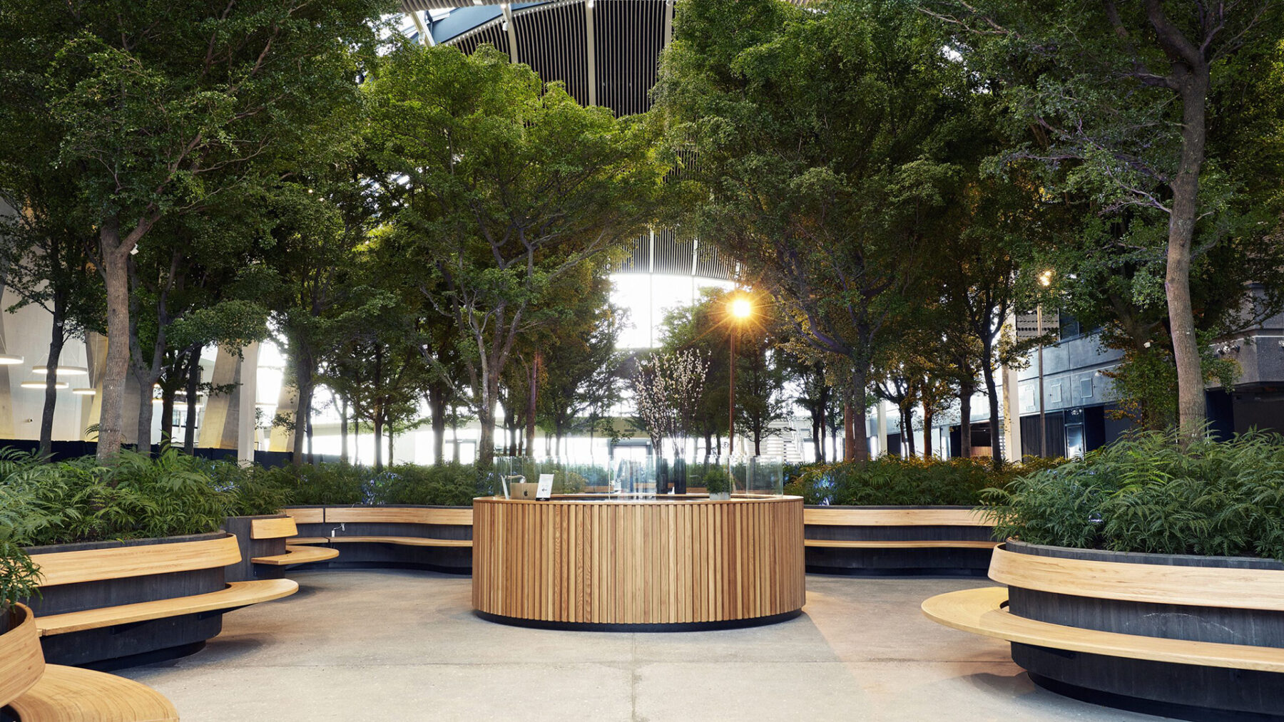 Indoor forest area with curved seating and reception desk inside Copenhagen Towers