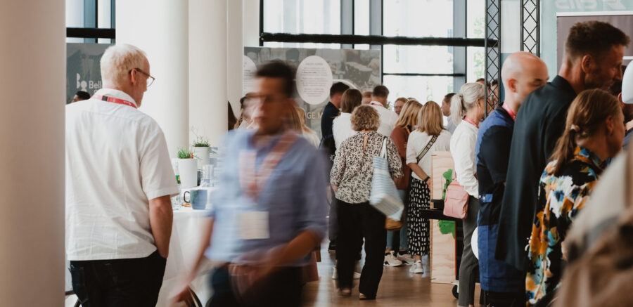 People networking at a professional business conference inside a modern venue with natural light
