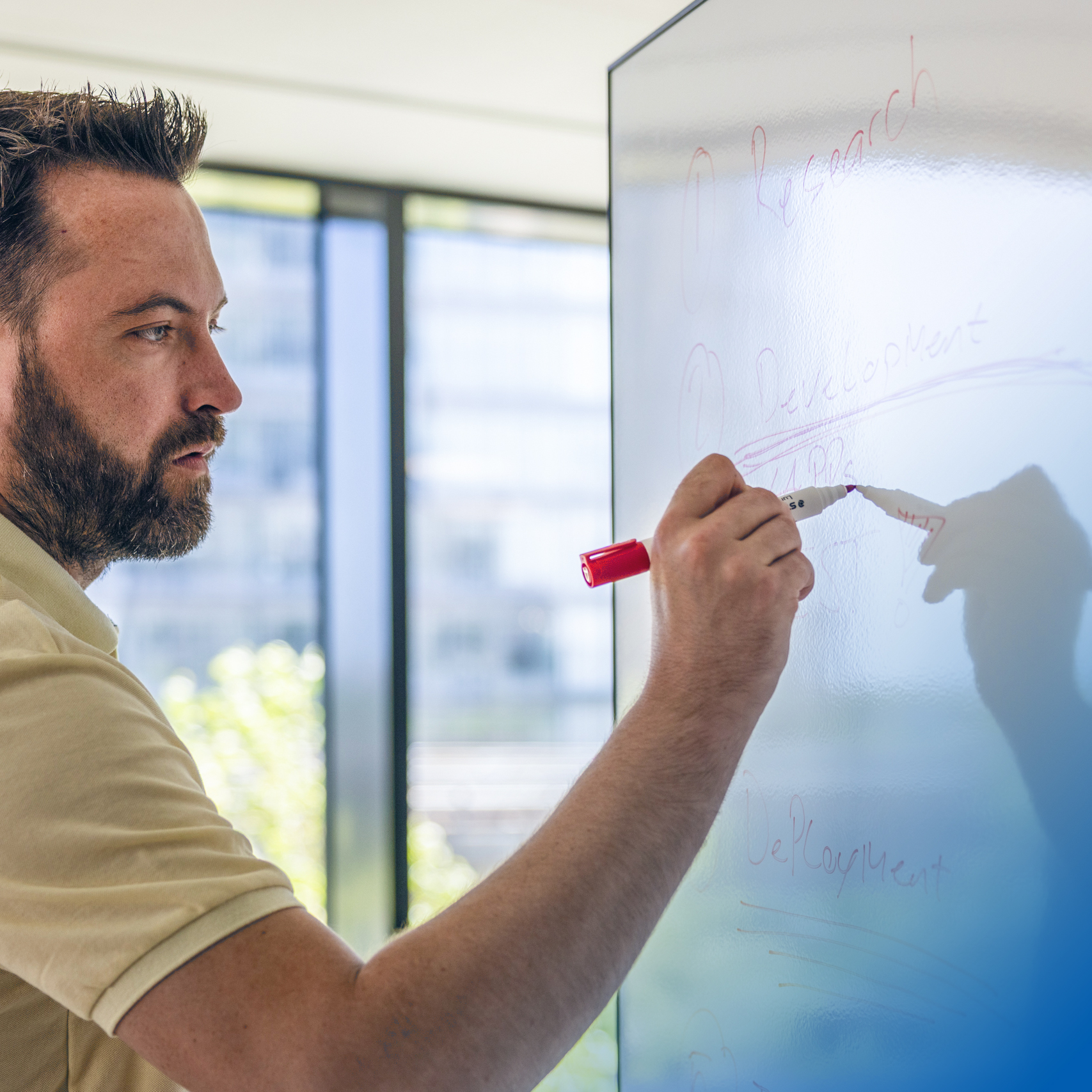 Team member mapping out development strategy on a glass board at Intellis headquarters